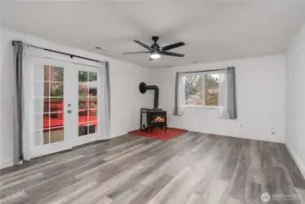 Huge recreation room with wood stove and French doors leading outdoors.
