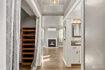 Hallway leading into primary bedroom with walk in closet, bath and fireplace.