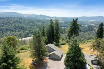 Drone picture of home facing west with territorial view of Orting Valley, and Carbon River below property.