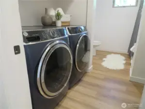 Washer and dryer with storage above, two kitchen sinks across and then beyond the rest of the full bathroom on upper level.