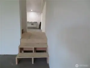 Lower part of the interior staircase that splits leading to the lower living room and the to the rest of the main living area: two bedrooms, dining area and kitchen, two bedrooms and 3/4 bath.