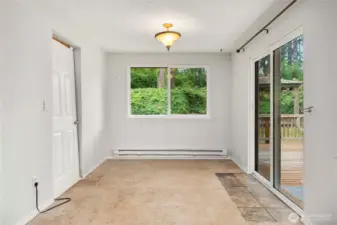 Separate dining space has a slider to the wrap-around deck. The door on the left enters the kitchen, but is currently blocked by the fridge.
