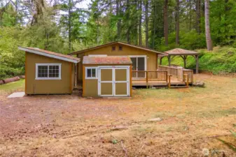 The far end of the home has the tool shed (straight ahead) and the "art studio" that is finished and has power (left side). Notice the large deck that wraps around from the door on the right side to the slider off the dining area.