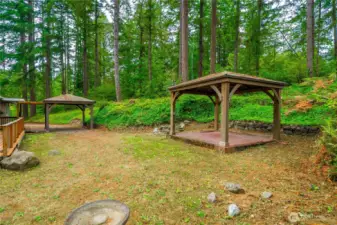 Another angle of the property, showing the gazebo, natural landscaping, and carport.
