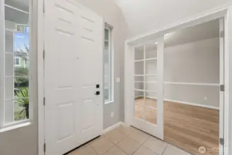 This is an entry that knows what it’s doing. A classic six panel front door, tall accent windows bringing in light without sacrificing privacy, and tile floors in a warm oatmeal tone that can handle wet shoes and busy mornings. The glass French doors to the den are the real flex here, close them for Zoom calls, open them when you want the space to breathe. It’s practical, good looking, and immediately makes sense, and the handsome new wood laminate floors are in the perfect warm wood tone to bring it all together.