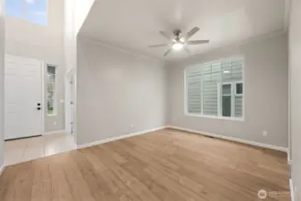 This space proves that flexibility is the new luxury. Swapping the traditional chandelier for a sleek ceiling fan turns this formal dining room into a true multi-purpose room that works just as well as a front living space. The huge window brings in serious daylight, and the view back to the entry shows off the two story vaulted foyer and that upper window pouring light down into the home. It feels open, airy, and ready to be used, not just admired.