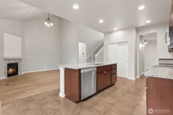 This view shows how smart the main floor really is. From the eating nook, you can see straight through the kitchen, past the island with the dishwasher tucked underneath, and into the vaulted family room anchored by the cozy corner fireplace. New lighting in the family room adds a fresh focal point, while the open connection to the butler’s pantry and formal dining room creates an easy circular flow. You can move from space to space without backtracking, which sounds small until you live with it and realize how much it matters.