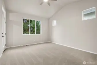 This primary suite checks all the right boxes. Vaulted ceilings create an airy feel, the oversized backyard-facing window brings in light and privacy, and the high accent windows give you flexibility for bed placement and furniture without blocking the view. Soft neutral carpeting keeps things cozy, while the modern ceiling fan adds comfort and a clean design element. Located on the main floor, it’s exactly the kind of bedroom you want at the end of the day.