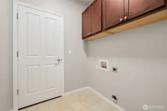 Laundry is right where you want it, on the main floor and out of the way. The room is sized for modern high efficiency machines, finished with easy care vinyl floors and upper cabinetry that ties in with the kitchen. A second doorway leads straight to the garage, making this space work double duty as a smart drop zone. Functional, tidy, and designed for daily life.