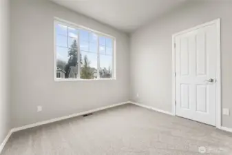 Bedroom #2 keeps things calm and versatile. Soft oatmeal carpeting warms the space, while the large front facing window with upper accent panels brings in natural light and a little architectural interest. High ceilings give the room breathing room, and the neutral palette makes it easy to style without committing to anything trendy. Every bedroom gets its own walk in closet here, which feels like a small luxury you quickly stop wanting to live without. Located in the Olympic View Elementary, Nisqually Middle, and River Ridge High school zones, this room works just as well for kids, guests, or upstairs den.
