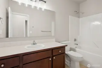 This upstairs bathroom is not messing around. An extra long vanity gives you real counter space, not the elbow bumping kind, with generous cabinetry to keep everything tucked away. The shower surround is clean and easy to maintain, paired with new sconce lighting that flatters instead of interrogates. All three bathrooms in the home feature brand new elongated toilets, because comfort matters. Add in the tall ten foot ceilings and this bathroom feels open, functional, and surprisingly elevated.
