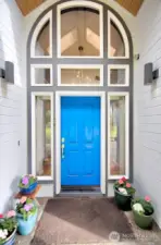 Entry to the home is covered by flower dappled portico, soaring window, and lots of light!