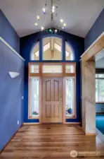 The entryway from the interior.  Gorgeous light fixture and gleaming wood floors sets the stage for the home.