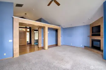 Living room looking back to entry and the den.  Vaulted ceiling and ceiling fan, corner propane fireplace.