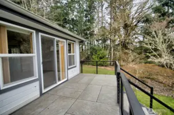 Deck along the back of the home overlooks the sloped lot and features seasonal view of the Nisqually Reach.