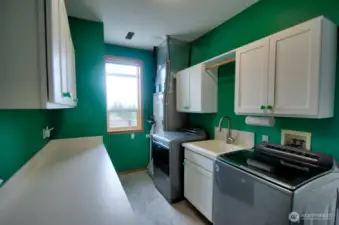 Mural of Mt. Rainier in the Utility room, with lots of cabinetry, washer and dryer, plus the heat pump which offers cooling.  Solar panels on the garage.