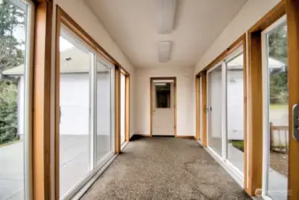 Aggregate pebble flooring and windows on both sides of the breezeway between the house and the double car garage.