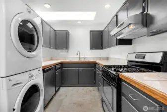 Kitchen area with stackable washer and dryer. This unit can be moved.