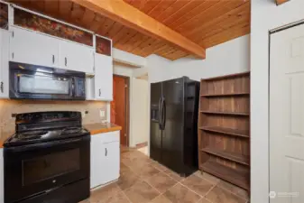 This kitchen is laid out for convenience in mind. The appliances are well-placed, and there's plenty of counter space for meal preparation and pantry shelving.