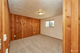 Another large secondary bedroom with natural wood with one painted wall