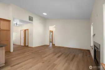 Open concept great room with vaulted ceilings, new flooring and gas fireplace.