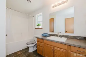 Upstairs guest bath with shower/tub combo and large vanity.