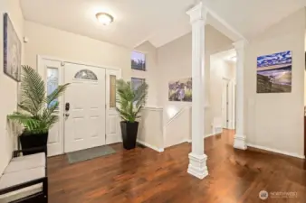 Impressive entry with wood laminate flooring and architectural accents and columns