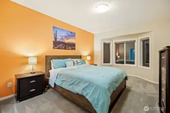 Primary suite on main level with bay window overlooking greenery