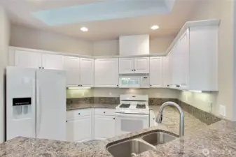 Open kitchen with dining pensinsula and granite counters. Undercabinet lighting and gas range!