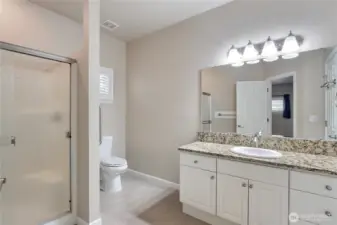 Primary bath with newer toilet and shower door.
