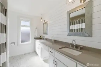upstairs hall bath with double sink and bathtub/shower