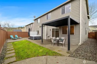 Upgraded backyard with patios, stepping stones, and a custom fencing system. There's a garbage can bay with double doors that can also be used as a dog run.