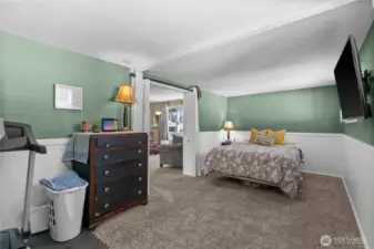 The primary bedroom is located off the living room and features charming wainscotting.