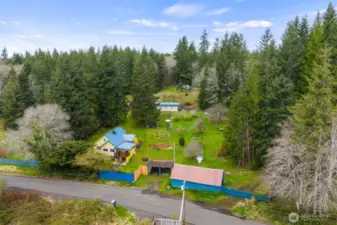 The home and outbuildings are located on the two parcels above Power's Creek Rd. Together they consist of approximately 11 acres, partially fenced. This photos gives you a pretty good look at the shop/rec room building on the lower right. And the other multi purpose building further up the hill.