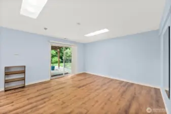 Ample lower level great room with pellet stove and doors that step out onto the fenced yard patio.