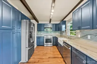 Well appointed Kitchen with Modern Appliances, pull out Trash Drawer Cabinet, and Wood Burning Pizza Oven tucked into the back of the fireplace.