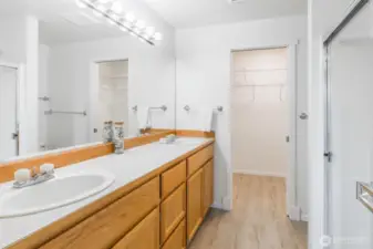 Primary suite bathroom with walk in closet beyond.