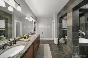 Elegant finishes, sleek dual sinks and refined design elements adorn the primary bath.