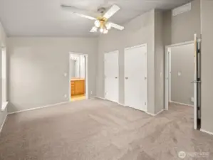 2 windows and vaulted ceilings keep the primary bedroom feeling light and airy
