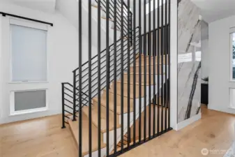 Custom steel staircase upstairs to 3 bedrooms & laundry and downstairs to luxury rich amenities and office and 4th bedroom