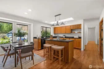 The spacious kitchen features solid oak cabinetry, a central island with bar stool seating and plenty of room for cooking, gathering, and everyday living.