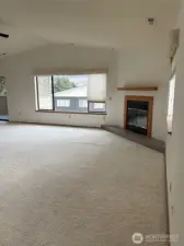 Living room with vaulted ceiling and fireplace.