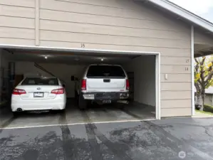Oversized two car garage with a car and truck parked easily inside.