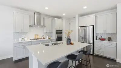 This beautifully designed kitchen offers clean lines, ample storage, and a stunning quartz island
