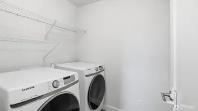 Upper-level laundry room offers easy access and efficient workspace.