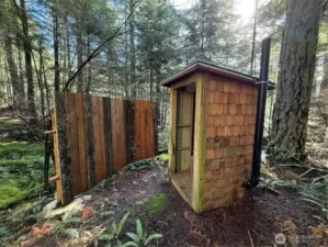 Newer outhouse on property situated with privacy fencing and just a short walk from the shelter