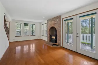 Large, open living room surrounded by windows and a wrap around deck.