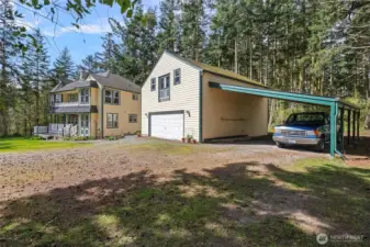 The carriage house features a large two car garage, attached two car carport, and a versatile living space upstairs.