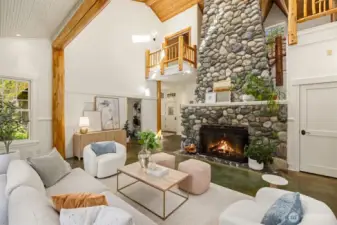 This fabulous living room somehow manages to be impressive and cozy at the same time. Note the lofted spaces above, overlooking the living room. The dramatic wood-burning stone fireplace is both beautiful and functional! It was designed with a parallel liner and a fan to return heated air back to the main floor, controlled by a rheostat switch.