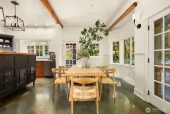 The large dining area cozies-up to the kitchen, but is separated by beautiful handmade glass-front cabinetry, lighted to display cherished items. The door straight ahead offers access to the large wrap-around patios and a fun gazebo housing a wood-fired pizza oven. French doors spill out to a covered area overlooking the grounds and pond.